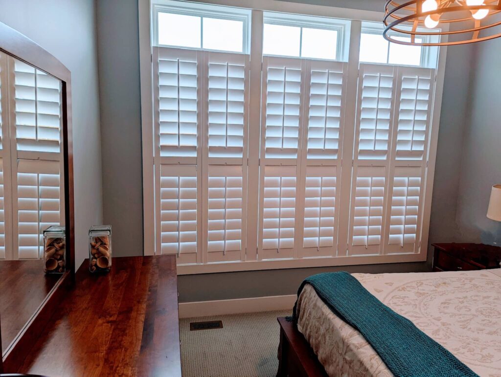 White window shutters in bedroom by Bartlett Blinds