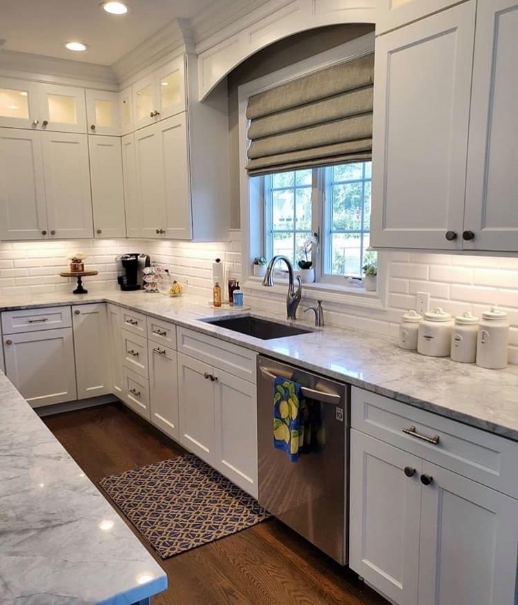 A kitchen with a window covered by Bartlett’s custom roman shades, providing privacy, temperature, and light control.