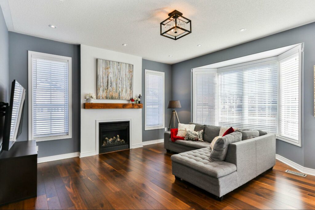 Living room space with hardwood flooring and white window blinds.