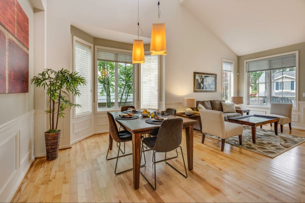 Large windows with natural lighting in a dining and living room space.