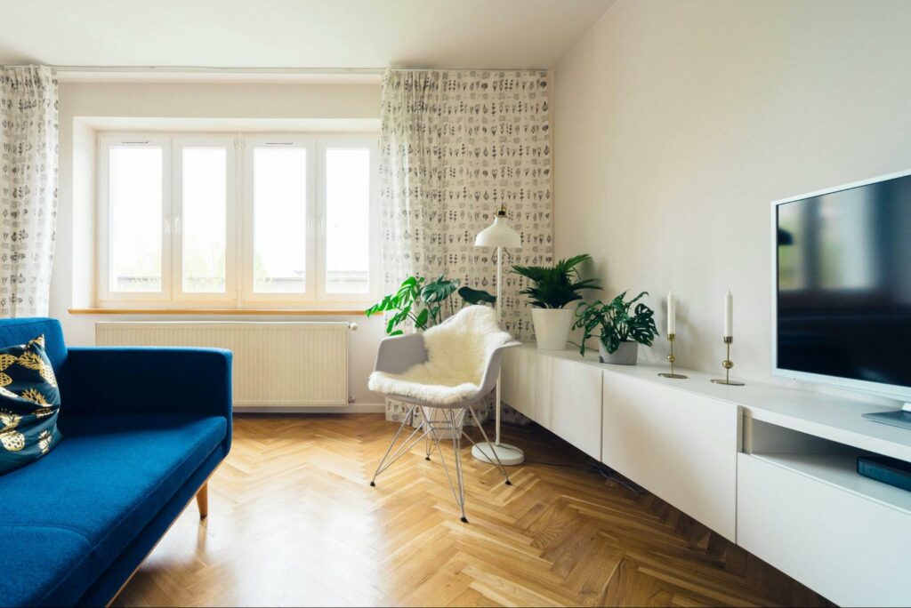 Furnished living room with natural lighting and floor-length curtains.